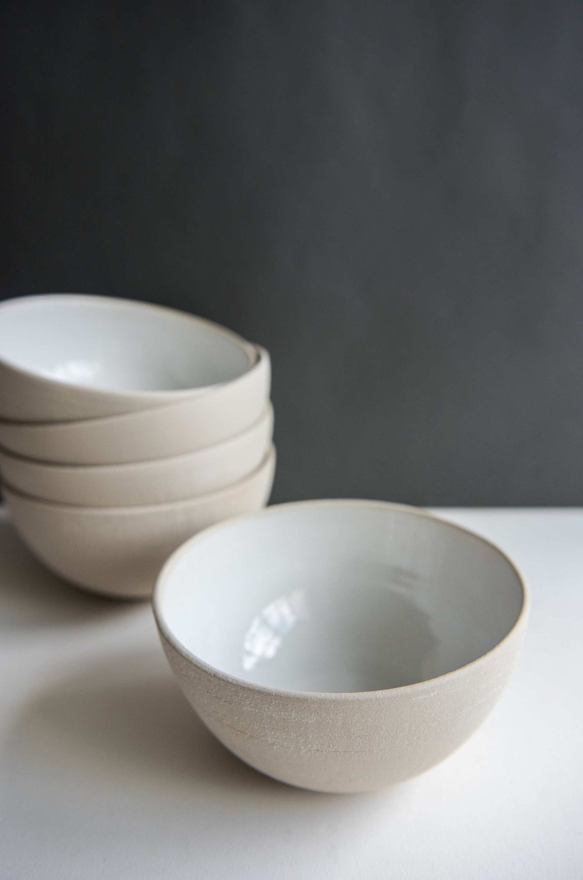 Handmade stoneware soup bowl with white glaze, rough textured exterior, and smooth interior, made in Ukraine