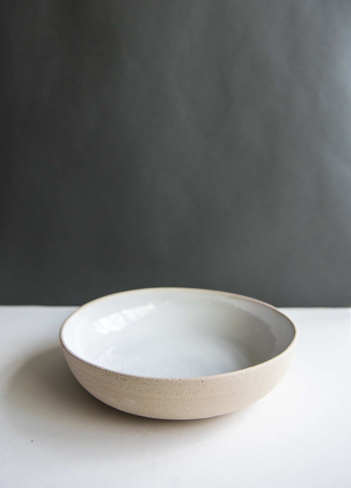 Stoneware Pasta Bowl with a smooth white glazed interior and a matte, speckled beige stoneware exterior.