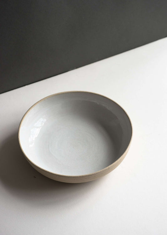 Stoneware Pasta Bowl in cream stoneware, with a smooth pale gray-white glazed interior and subtle textured exterior.