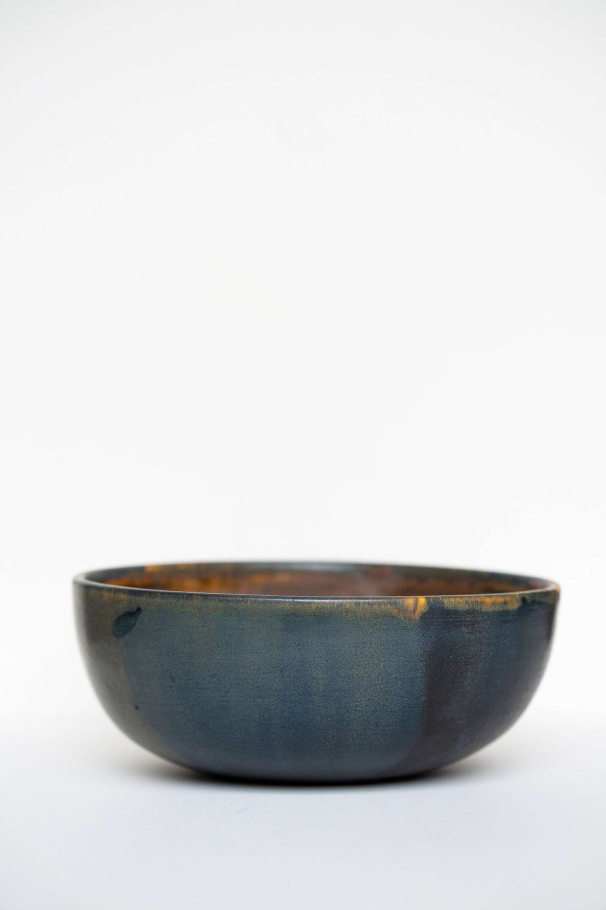 Rust stoneware nesting bowl set with matte brown-black reactive glaze, handcrafted and stackable