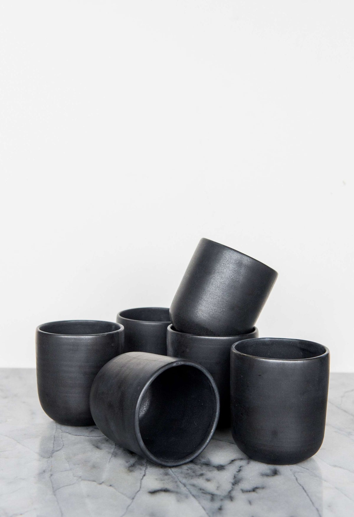 Black matte handmade stoneware cup with organic edges for coffee and tea