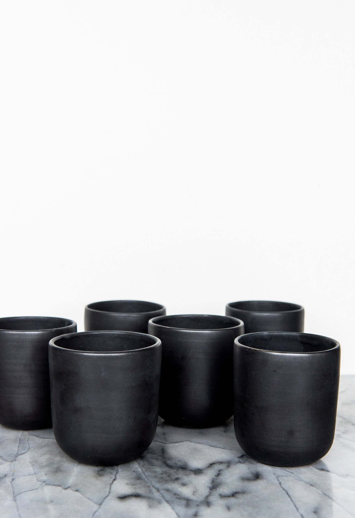 Black matte handmade stoneware cup with organic edges for coffee and tea