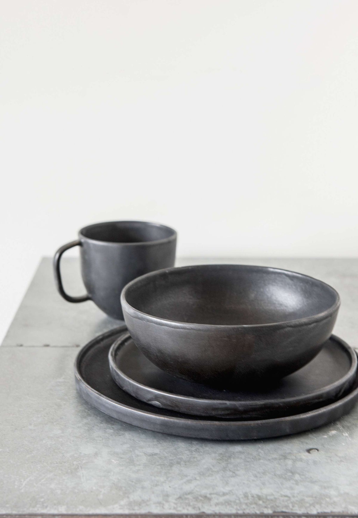 Black matte stoneware coffee mug with reactive glaze and ergonomic handle