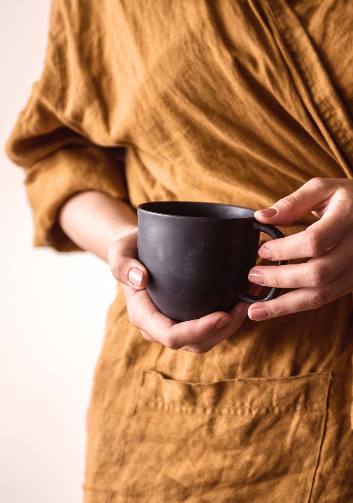 Handcrafted black matte stoneware coffee mug with unique reactive glaze and comfortable handle