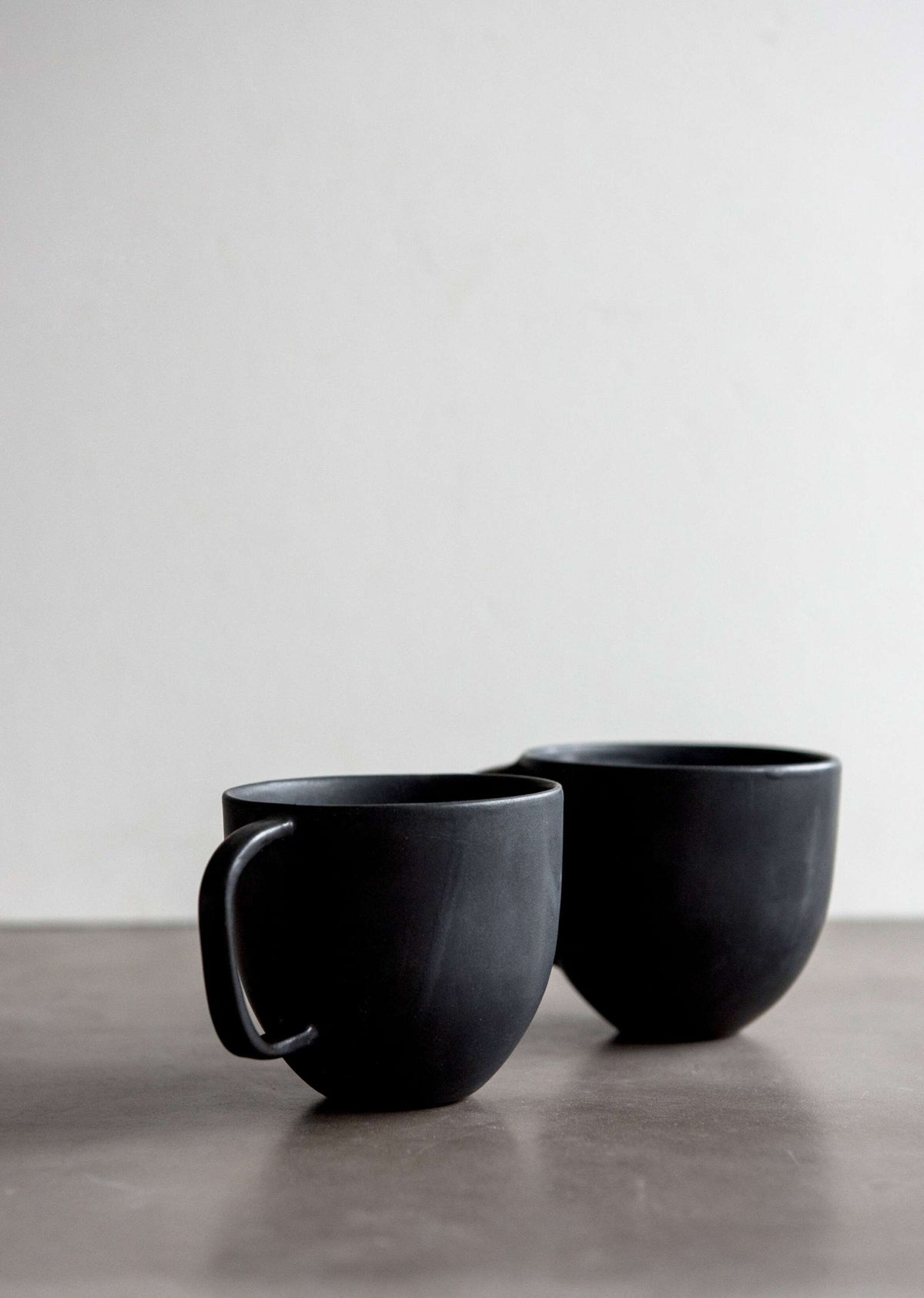 Handcrafted black matte stoneware coffee mug with reactive glaze and comfortable handle
