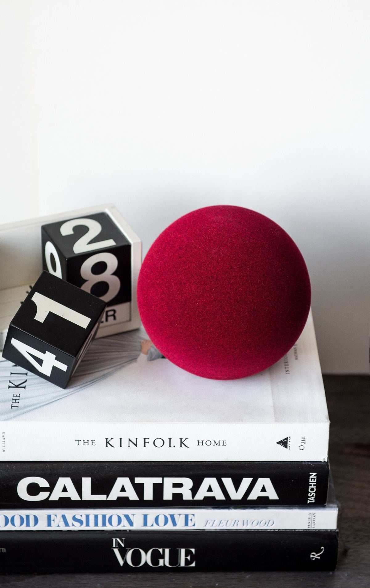 Porcelain set of home decor with burgundy geometric vases including a tall tube vase, round vase, and sphere