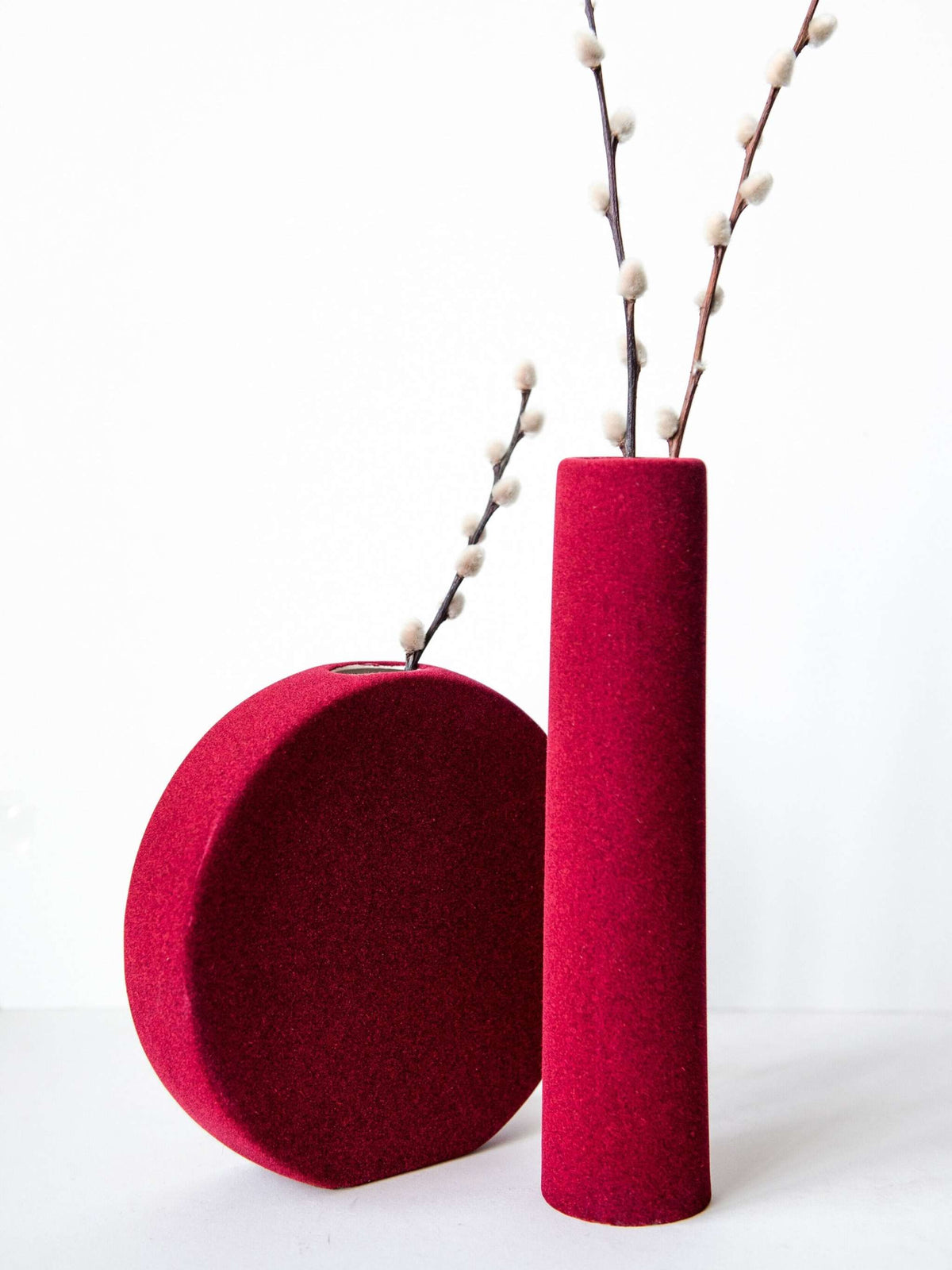 Porcelain set of home decor with burgundy geometric vases including tall tube vase, round vase, and sphere