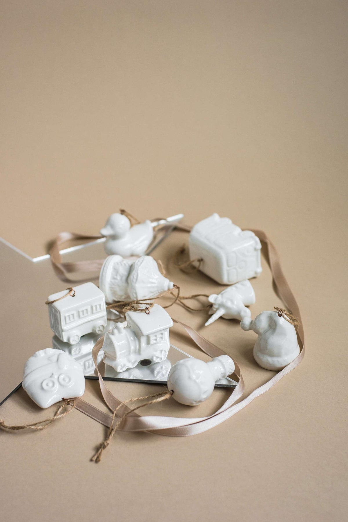 Handmade white porcelain Christmas ornaments with rustic jute loops, made in Ukraine for holiday decor