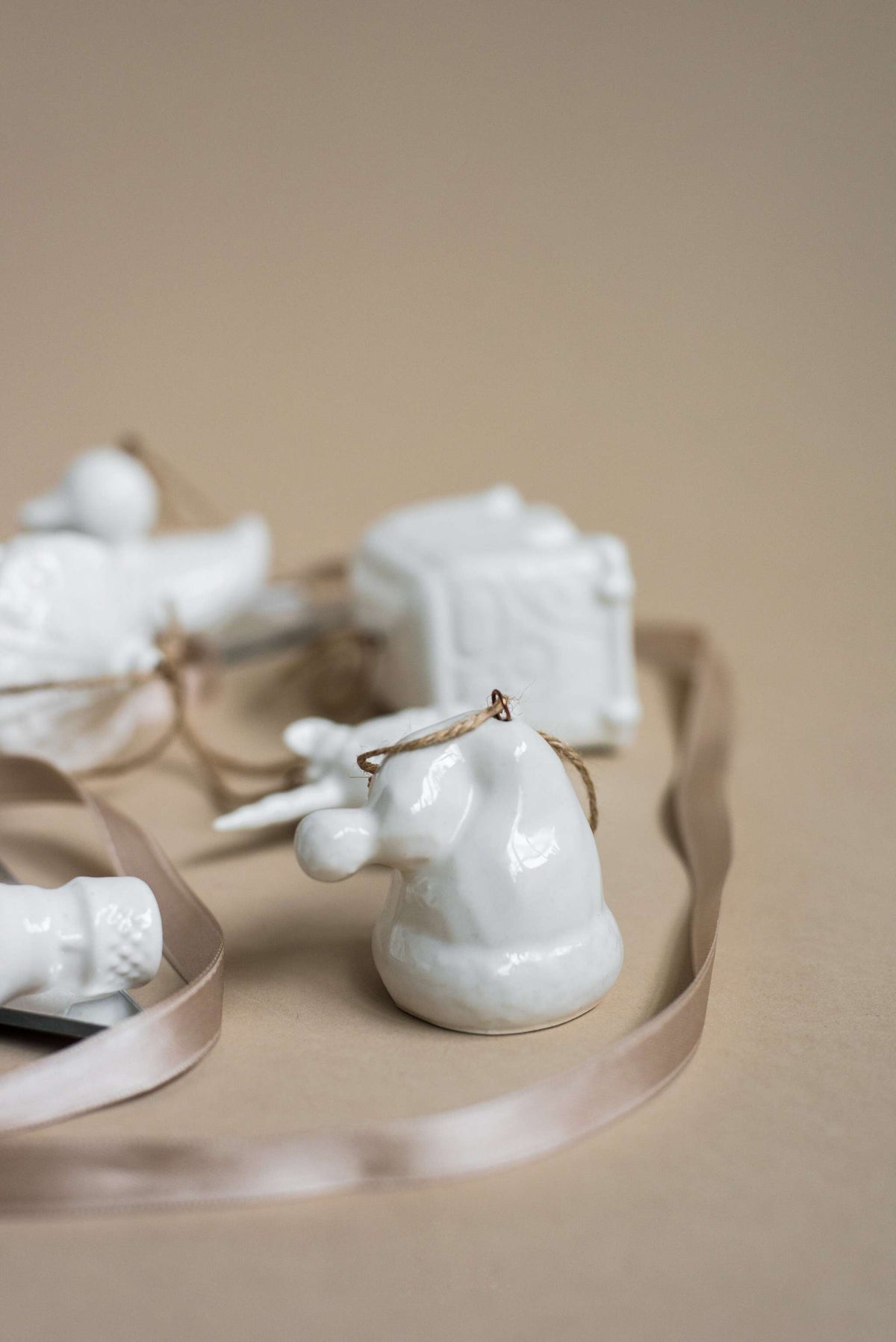 White handmade porcelain Christmas ornaments with jute hanging loops, rustic holiday decor made in Ukraine.