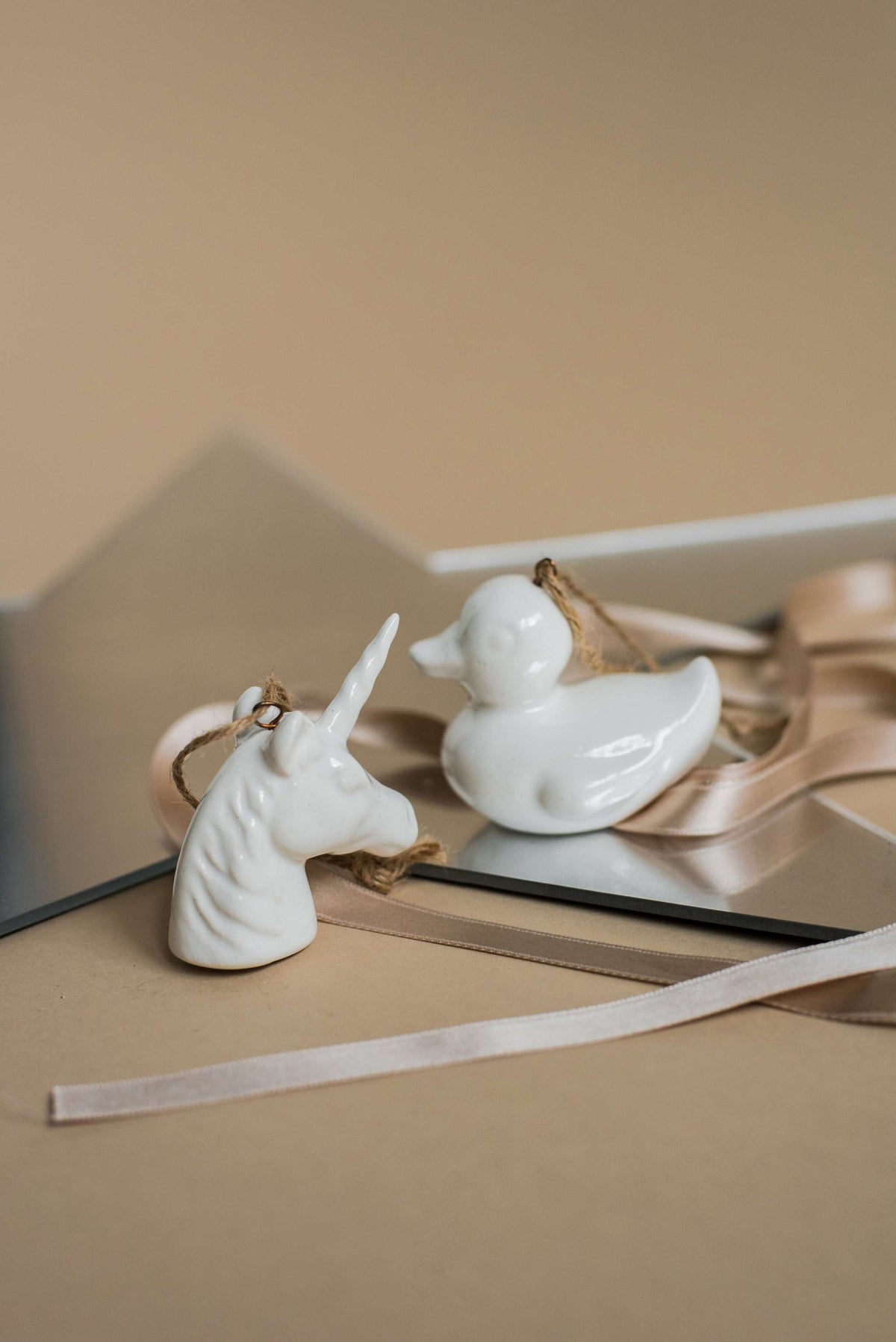 Handmade white porcelain Christmas ornaments with rustic jute loops, made in Ukraine, for holiday decor and charity support