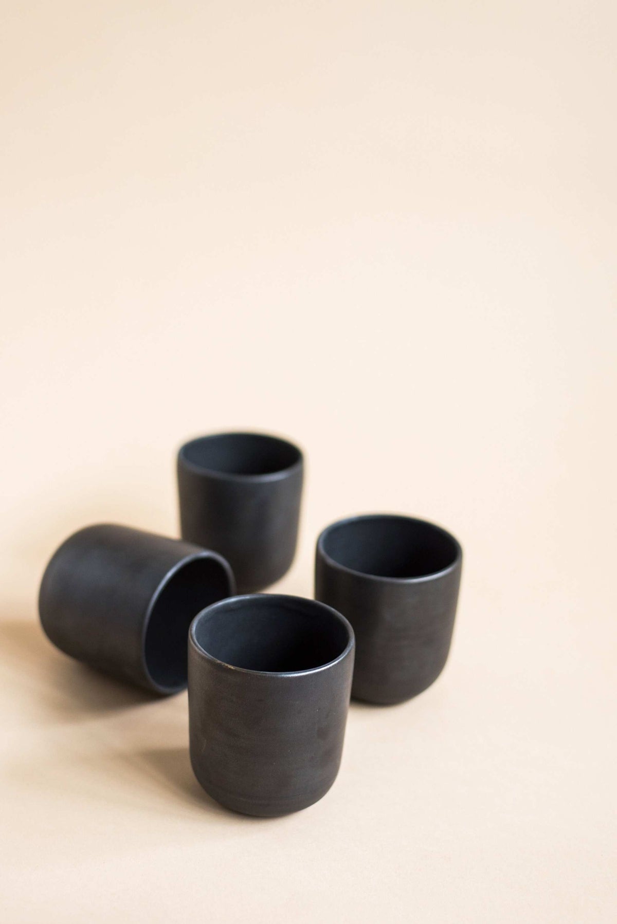 Black matte handmade stoneware cup with organic edges for coffee and tea