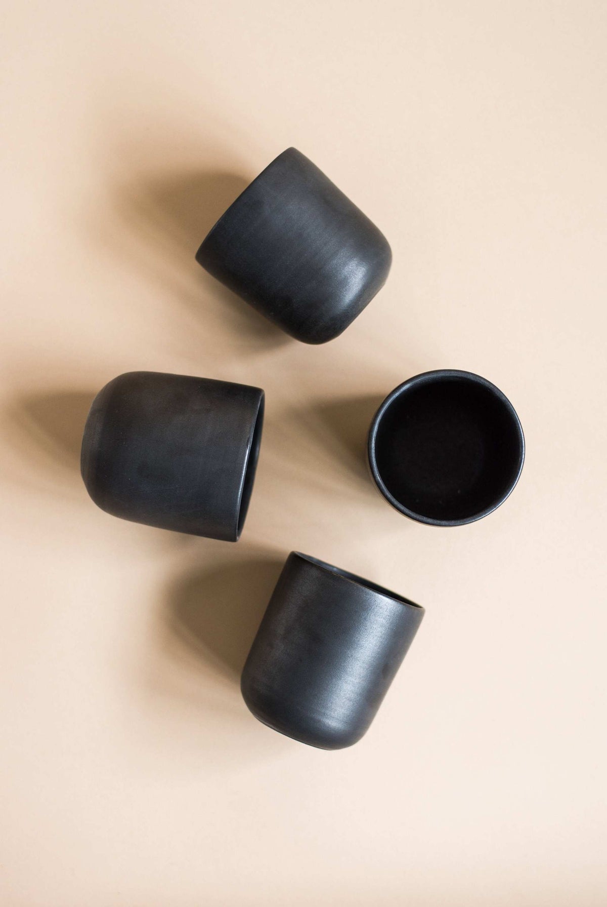 Black handmade stoneware cup with matte finish and organic edges for coffee and tea