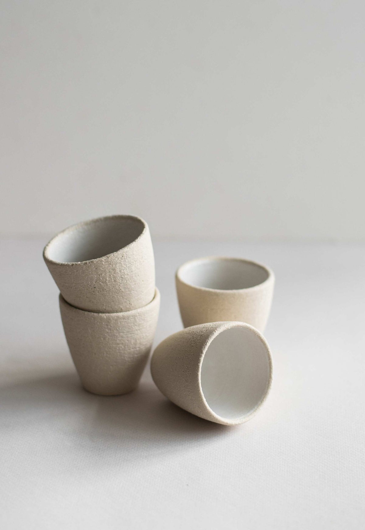 Handmade stoneware espresso cup with white glaze and exposed clay, dishwasher-safe and lead-free