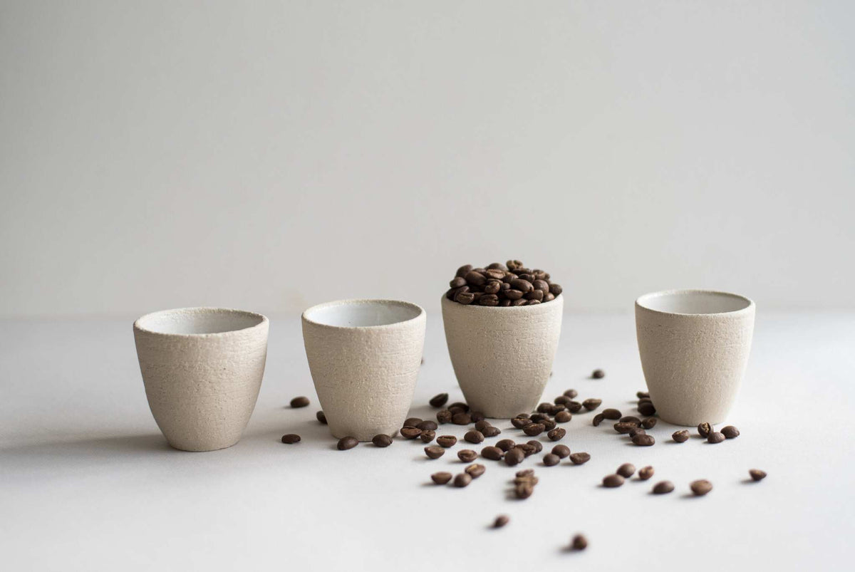 Handmade stoneware espresso cup with exposed clay and white interior glaze