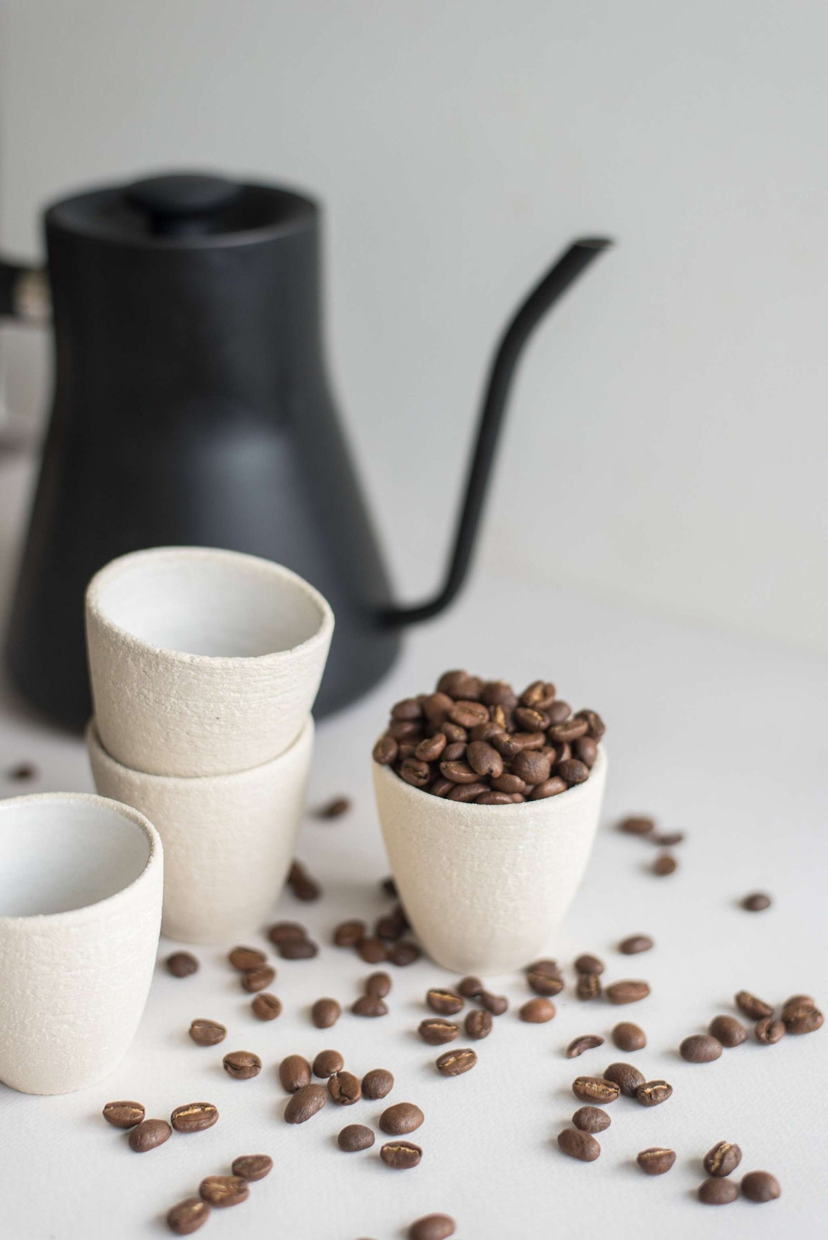 Handmade stoneware espresso cup with exposed clay exterior and white glazed interior, dishwasher-safe and made in Ukraine