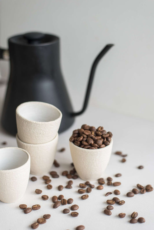 Handmade stoneware espresso cup with exposed clay exterior and white glazed interior, dishwasher-safe and made in Ukraine