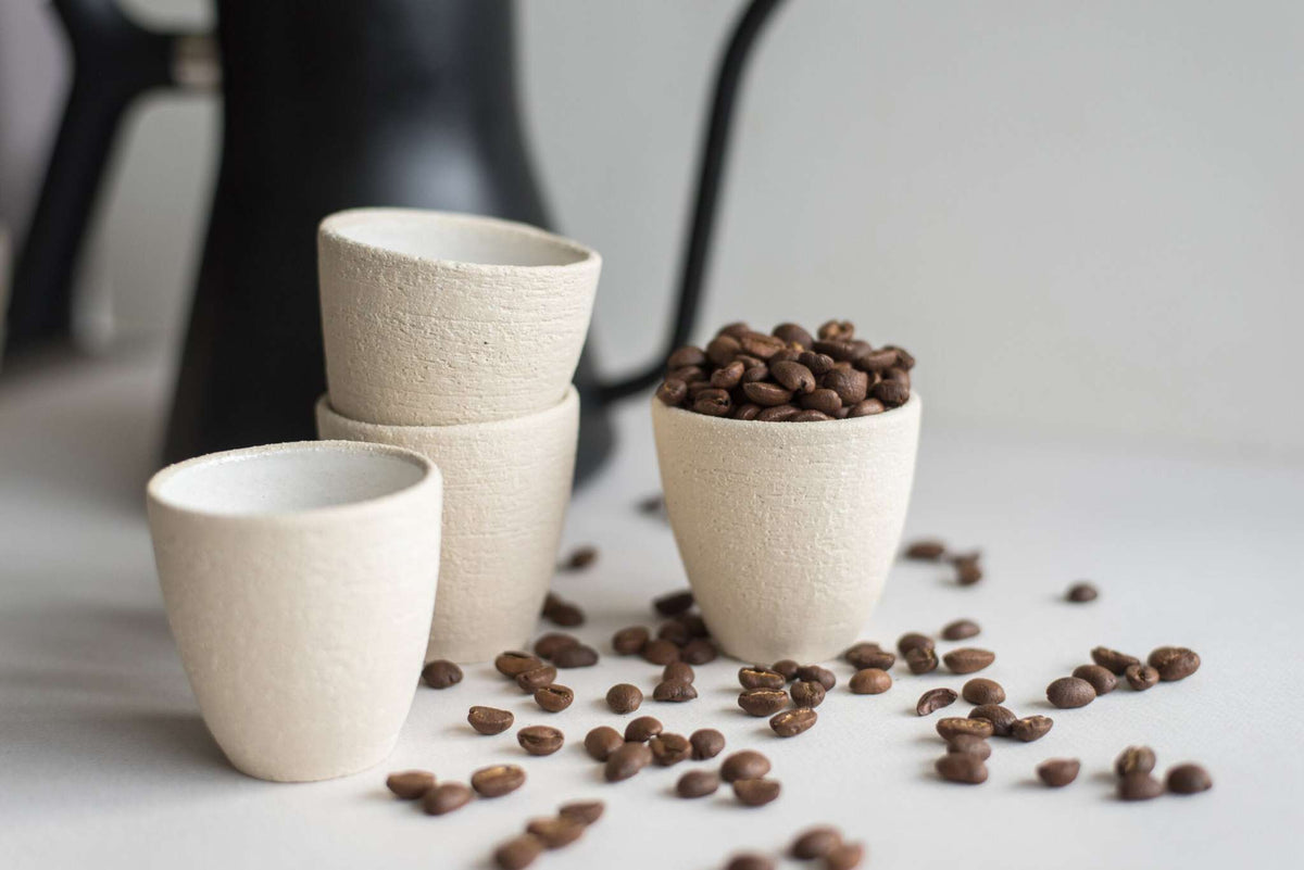 Handmade stoneware espresso cup with exposed clay exterior and white glazed interior, small and textured, made in Ukraine