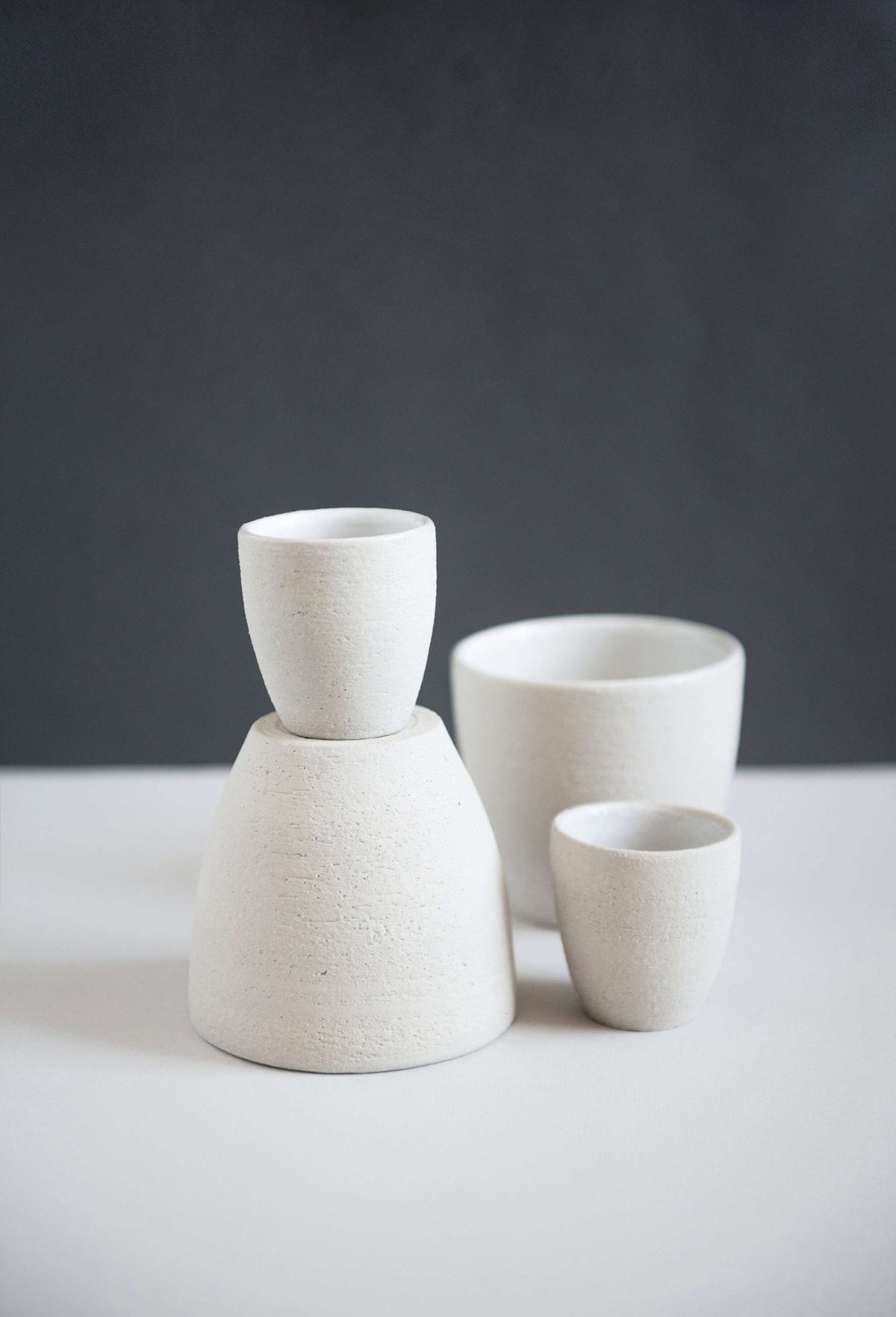 Handmade stoneware coffee cup with white glazed interior and rough textured exterior, crafted in Ukraine