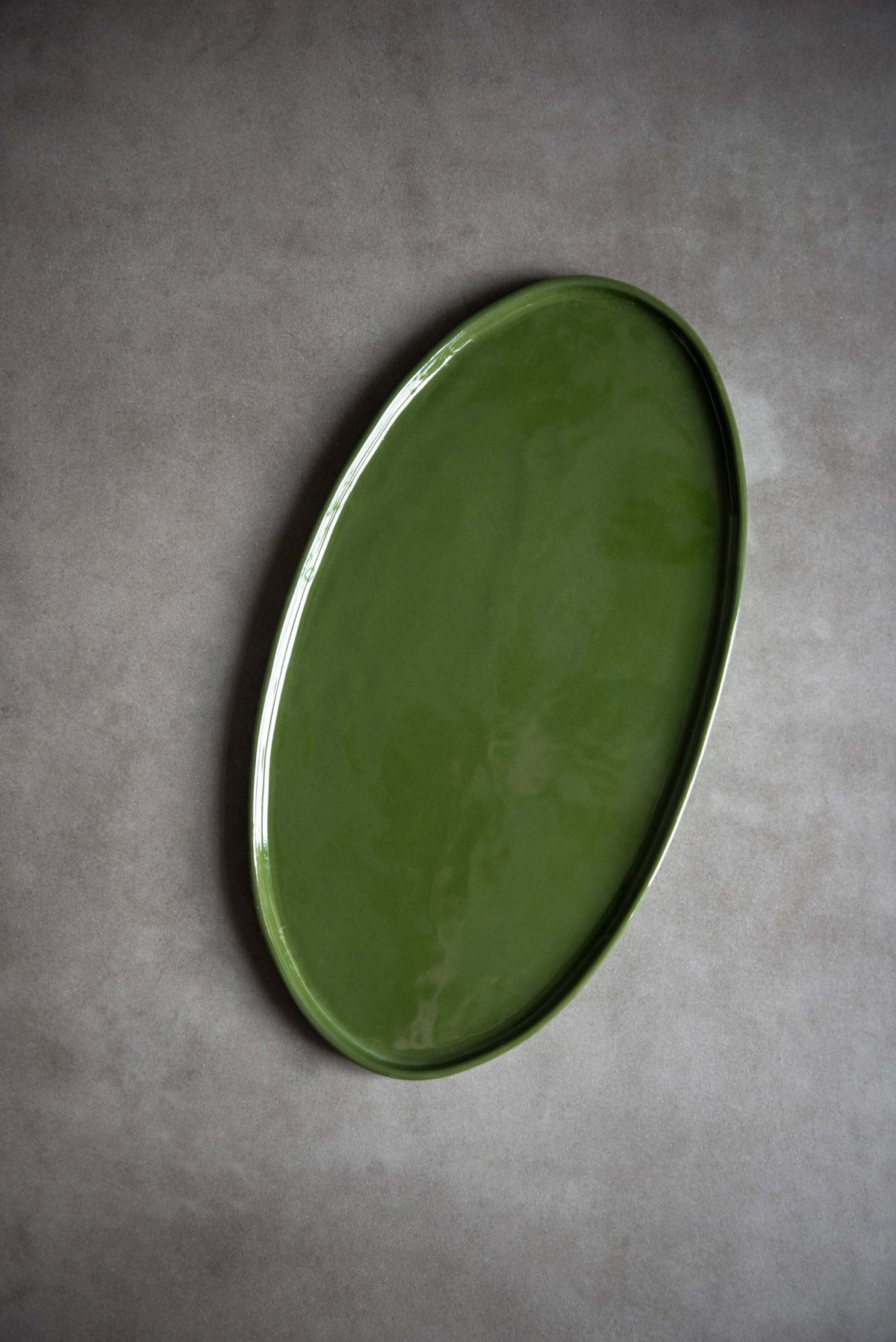 Handmade green oval porcelain platter with rounded edges for serving food