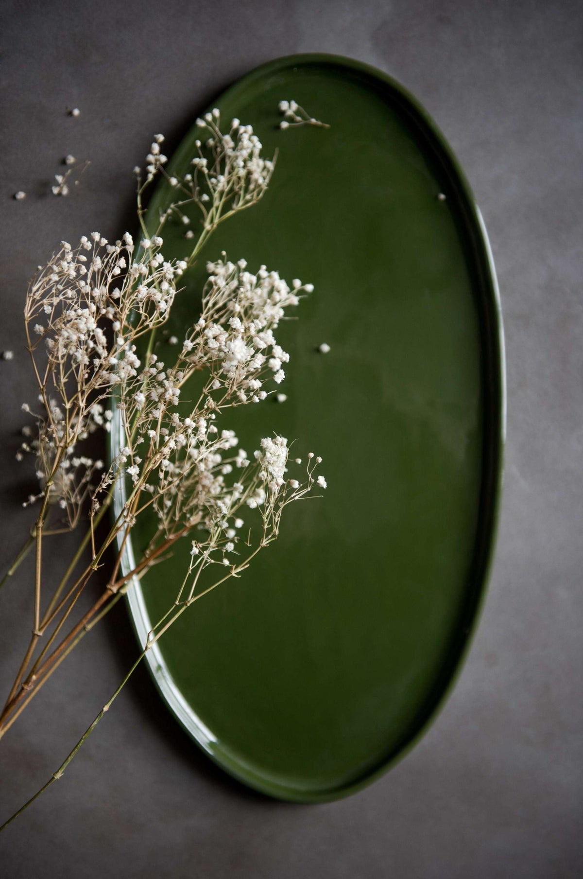 Handmade green oval porcelain platter with rounded edges for elegant serving