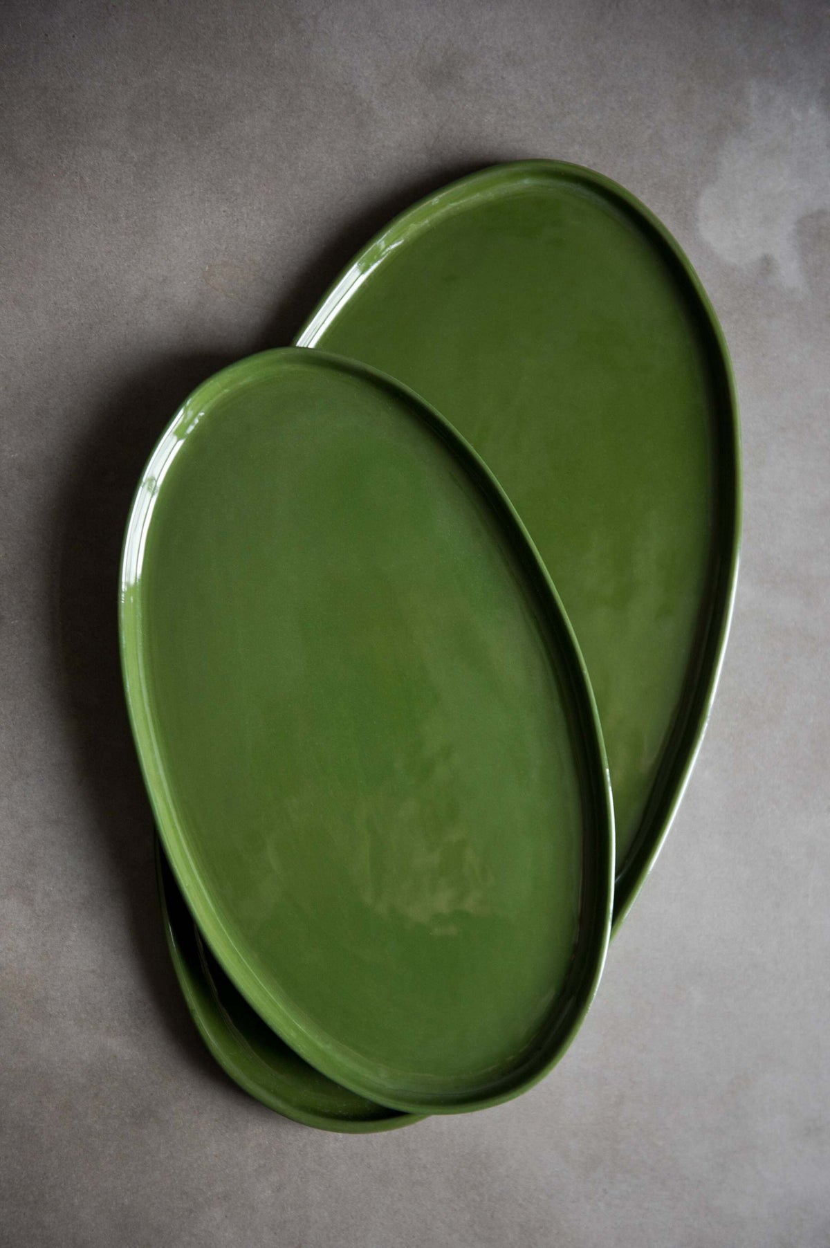 Handmade green oval porcelain platter with rounded edges for elegant serving and dining