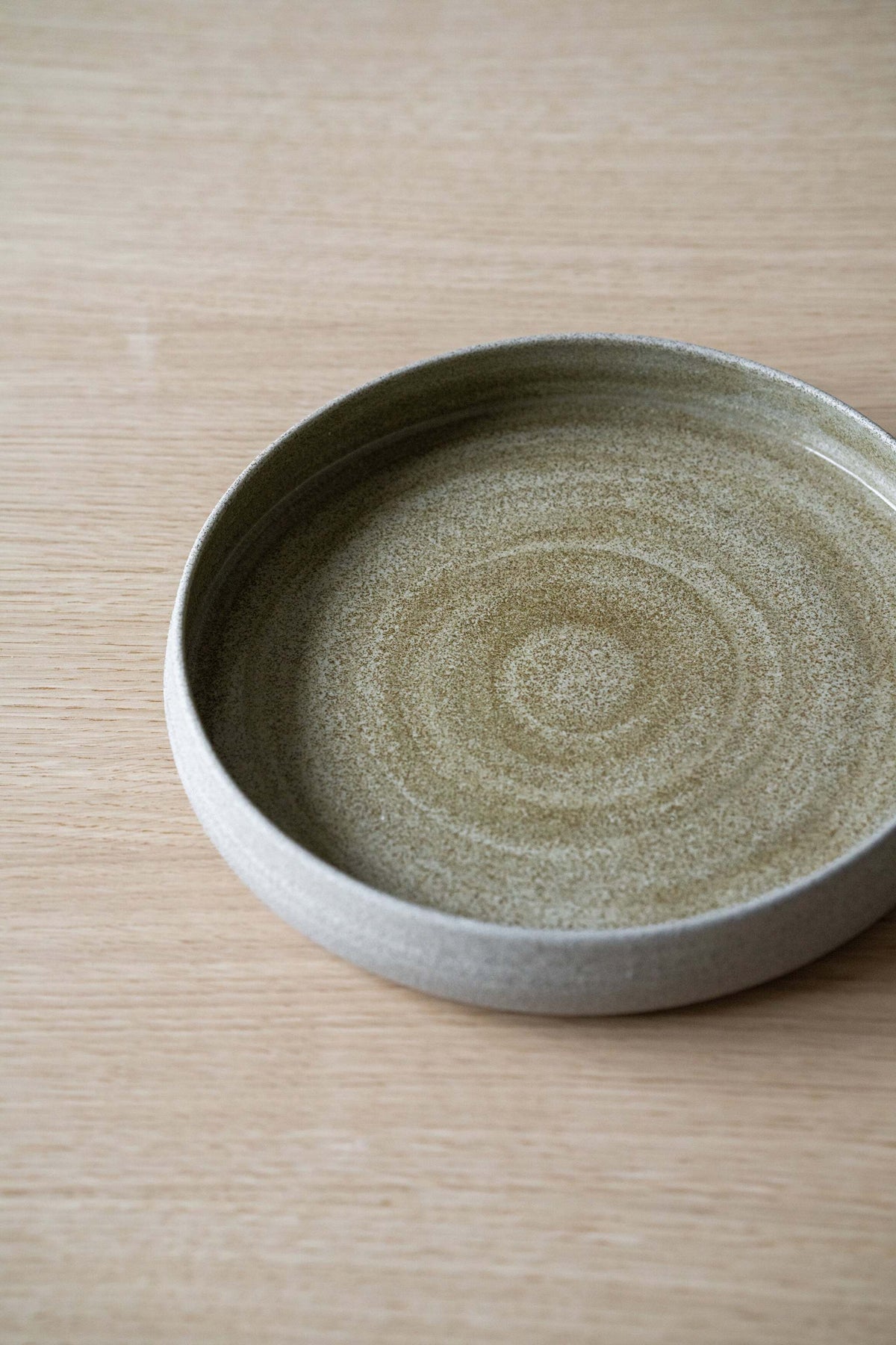 Handmade stoneware dinner plate with high sides in concrete style, glossy interior and textured exterior