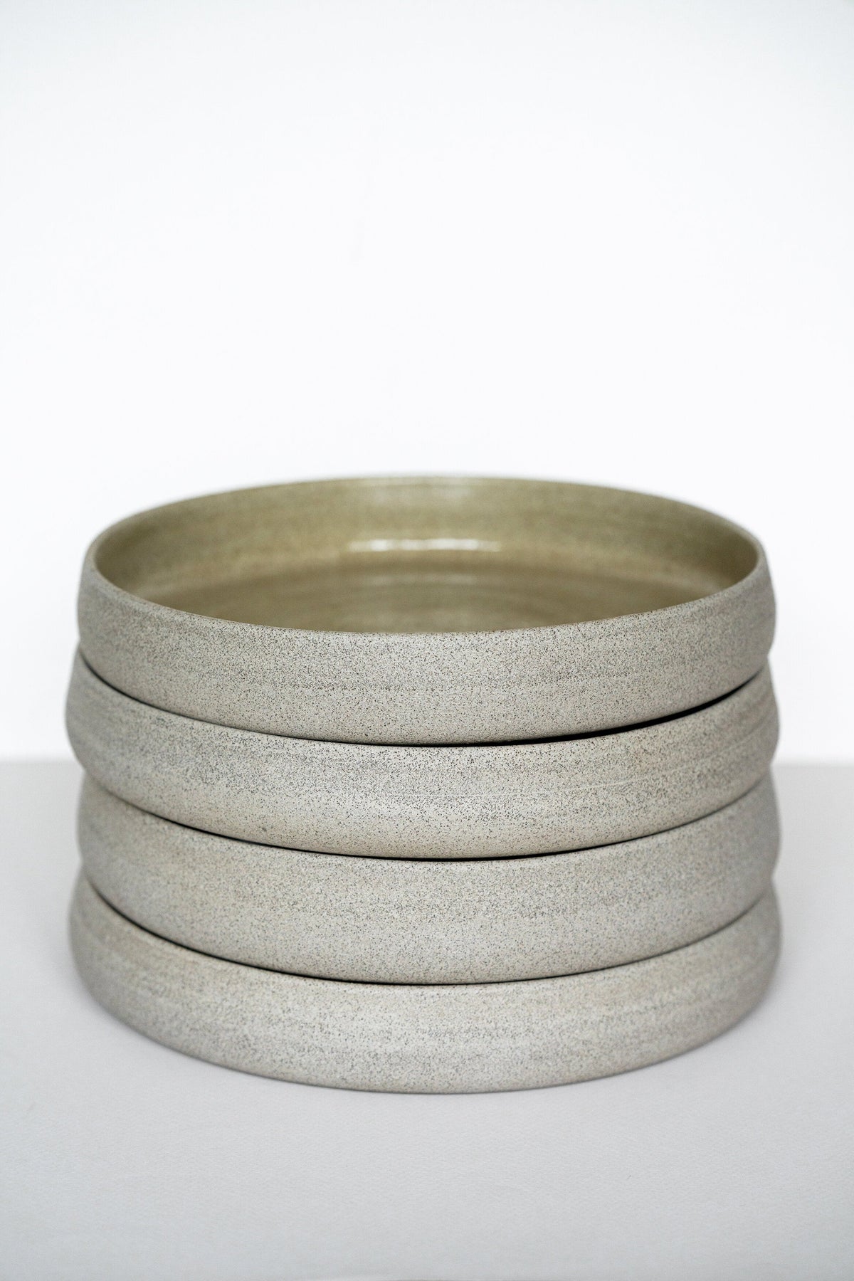 Handmade stoneware dinner plate with high sides in concrete style, polished exterior and glossy glazed interior, dishwasher and microwave safe