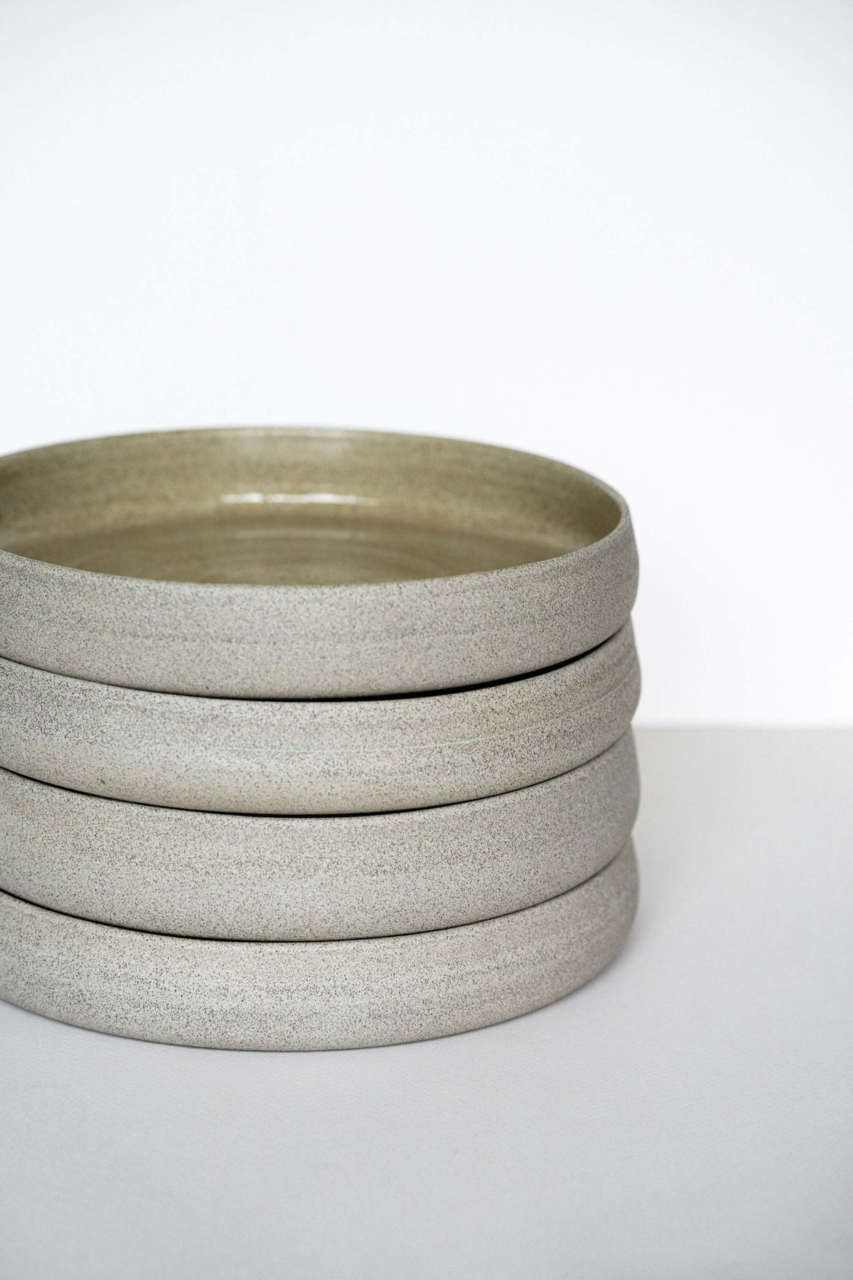 Handmade stoneware dinner plate with high sides in concrete style, glossy glazed inside and rough textured outside