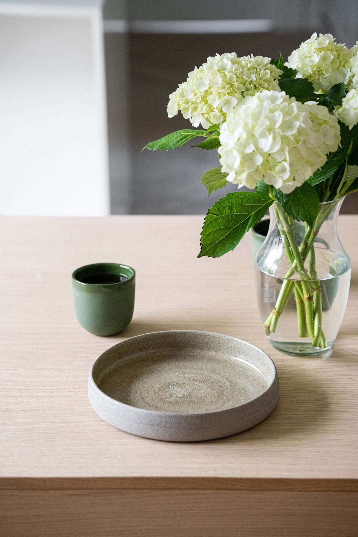 Handmade stoneware dinner plate with high sides in rustic concrete style, glossy glazed interior and rough exterior texture
