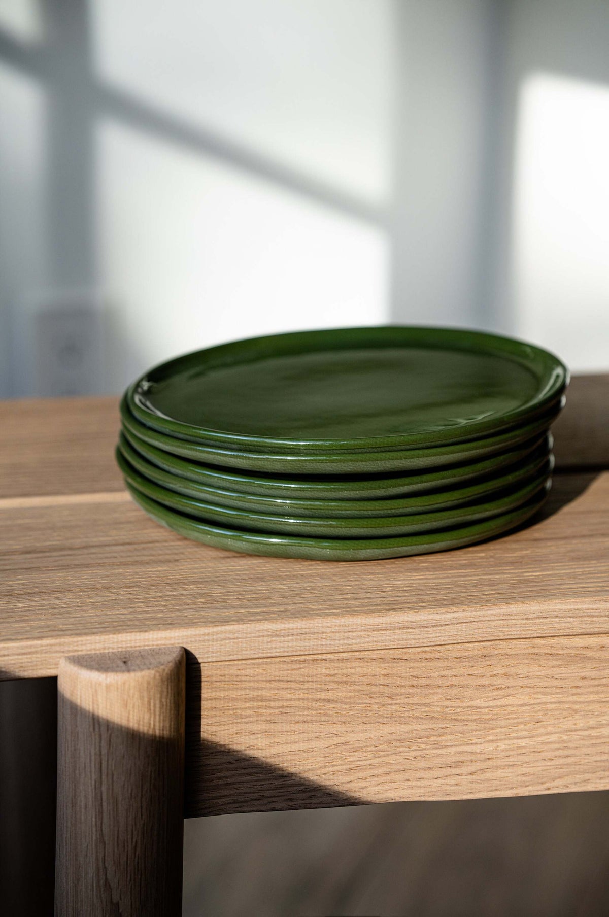Set of handmade green porcelain dinner and salad plates with shiny glaze and smooth finish