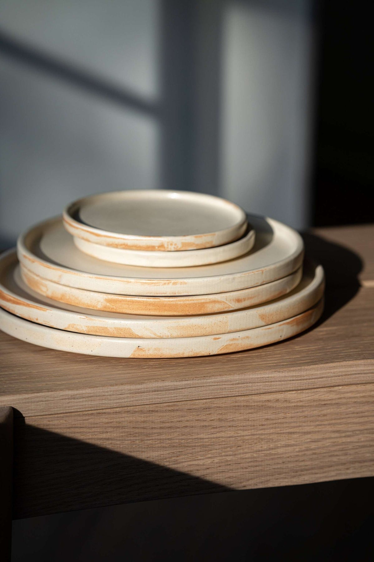 Beige matte stoneware dinner plates with unique reactive glaze and simple geometric design