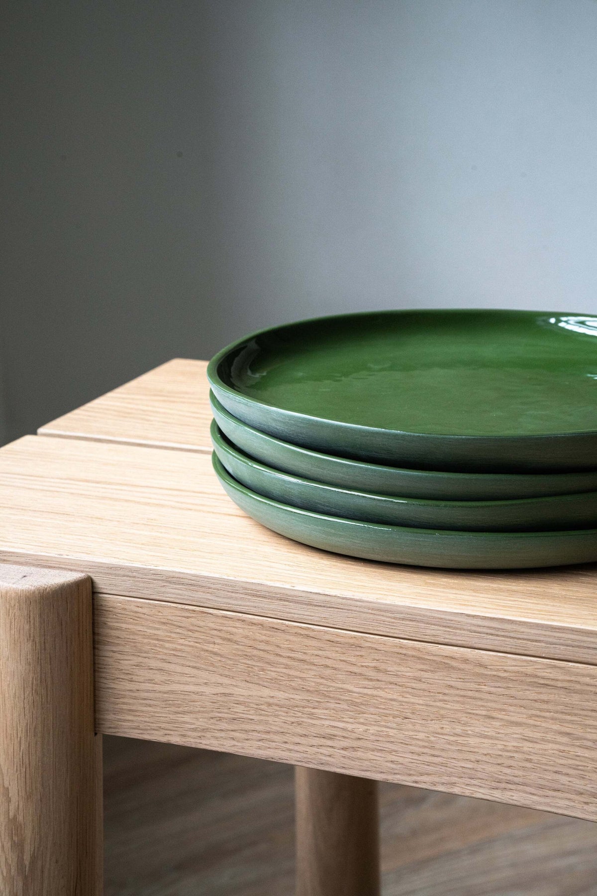 Set of handmade green porcelain dinner and salad plates with shiny glaze and smooth polished finish
