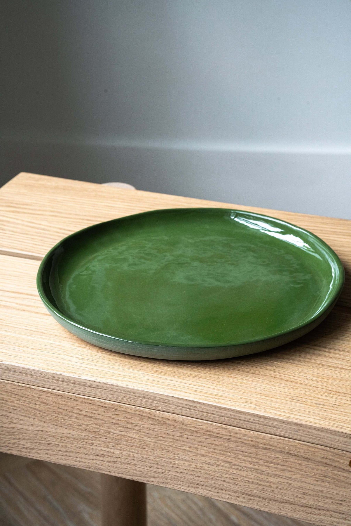 Set of green handmade porcelain dinner plates with shiny glaze and smooth finish
