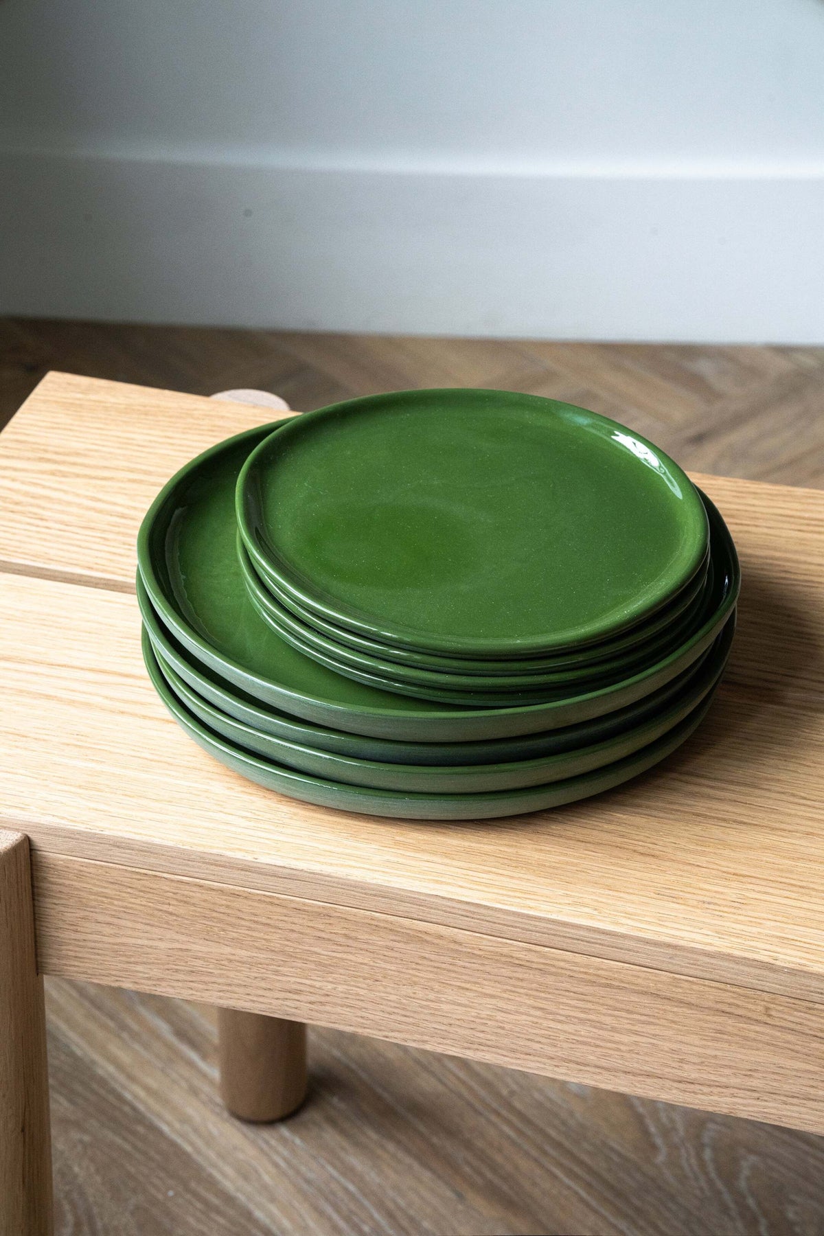 Set of green handmade porcelain dinner plates with shiny glaze and smooth finish