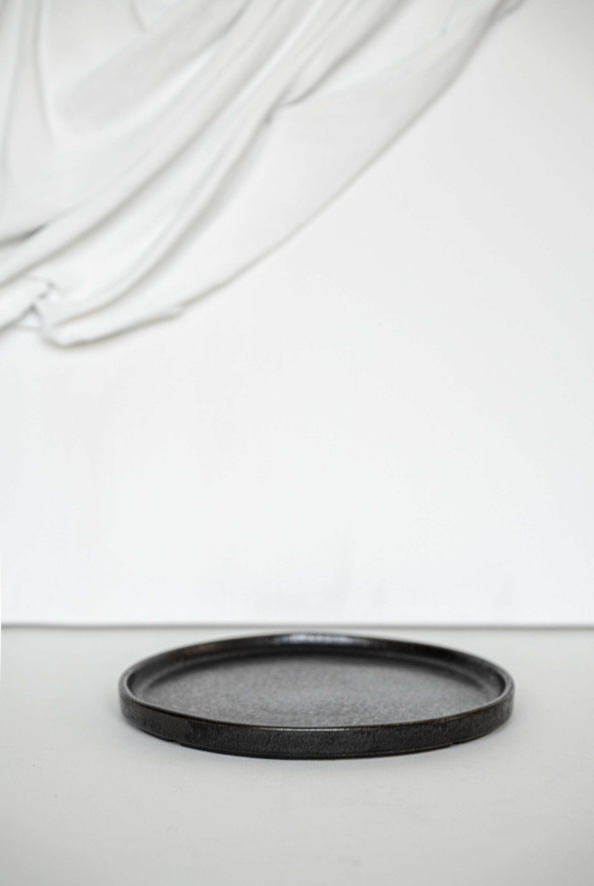 Black stoneware dinner plates with glossy speckled glaze and light border ring