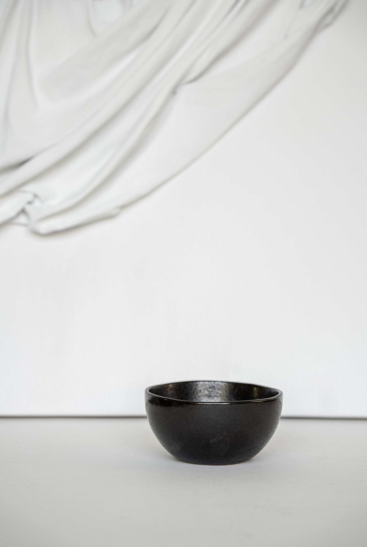Black stoneware mini bowl with matte glaze and glossy speckles, handmade and food-safe