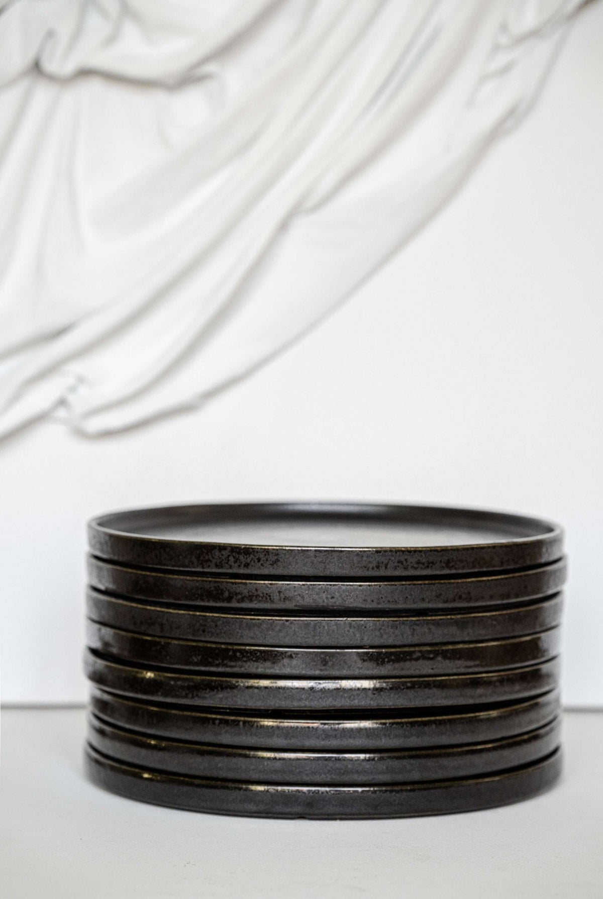 Black stoneware dinner plates with glossy speckled glaze and organic rims for everyday and special occasions
