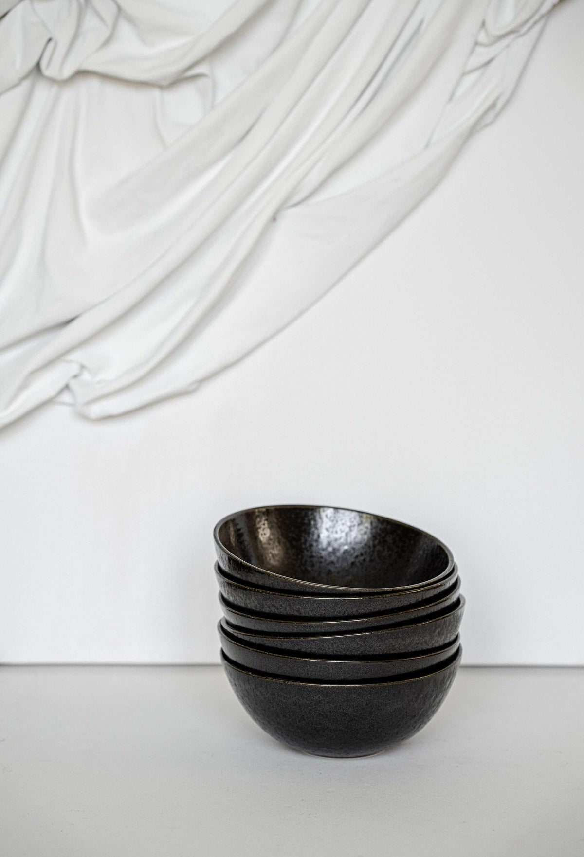 Matte black stoneware everyday bowl with glossy speckles and organic curves, handmade in Portugal