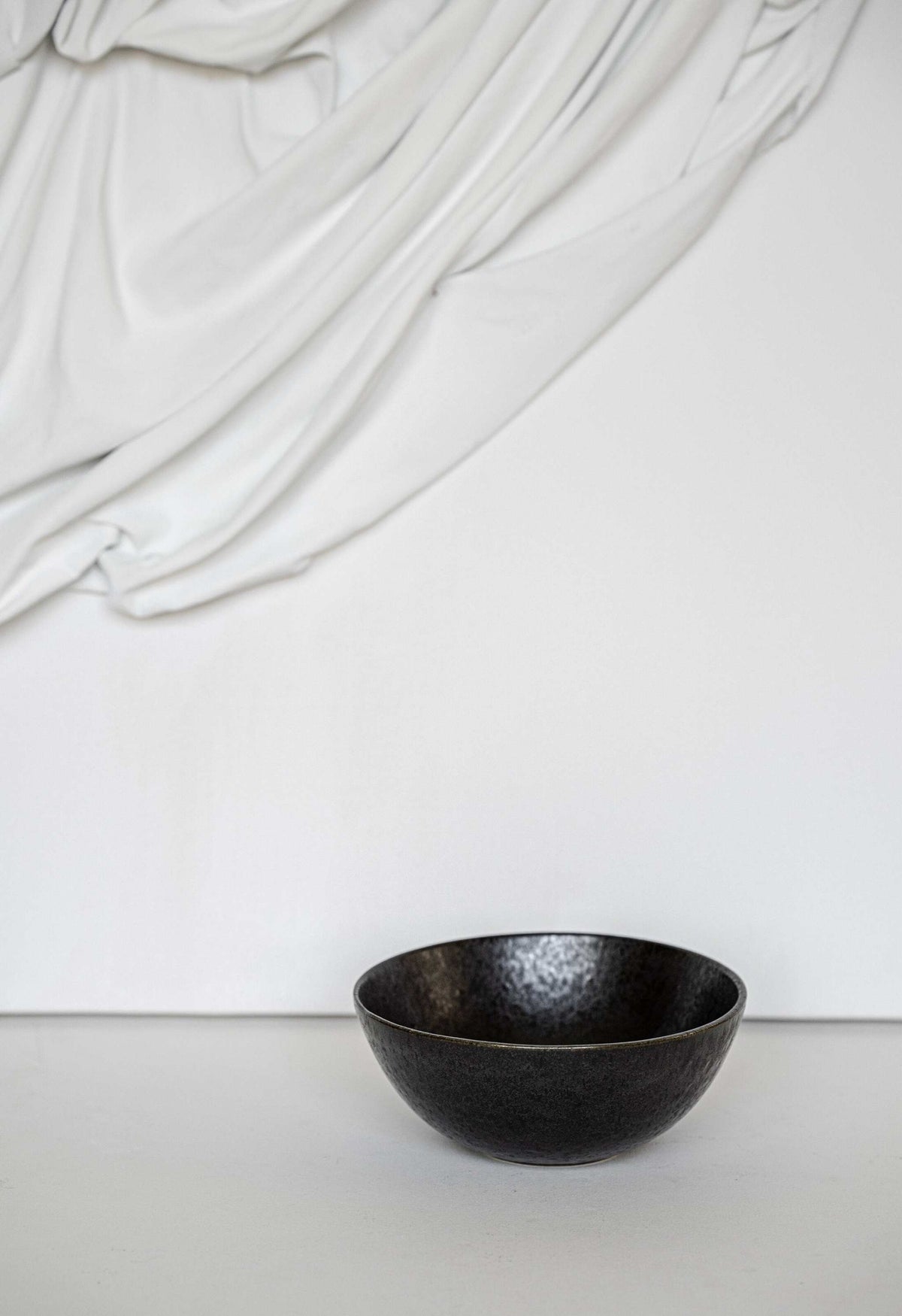 Matte black stoneware everyday bowl with glossy speckles and organic curves, handmade in Portugal