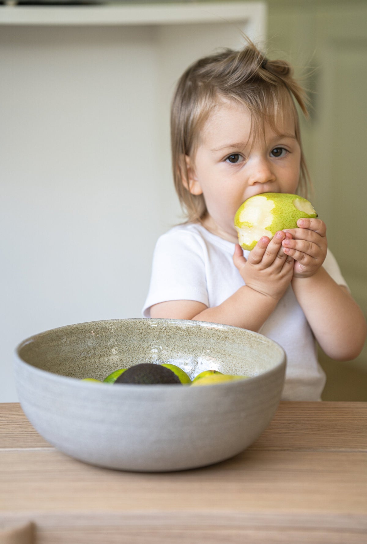 Stoneware large fruit bowl "Concrete" with polished exterior and glossy interior filled with fresh fruits