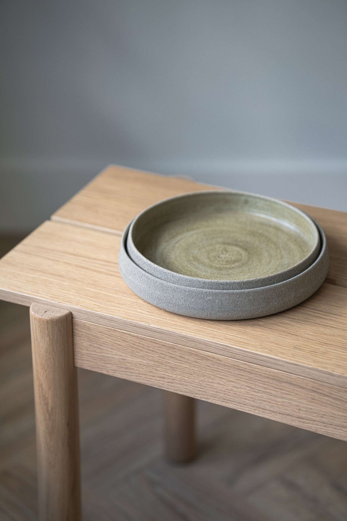 Handmade stoneware dinner plate with high sides in concrete-like texture and glossy interior glaze