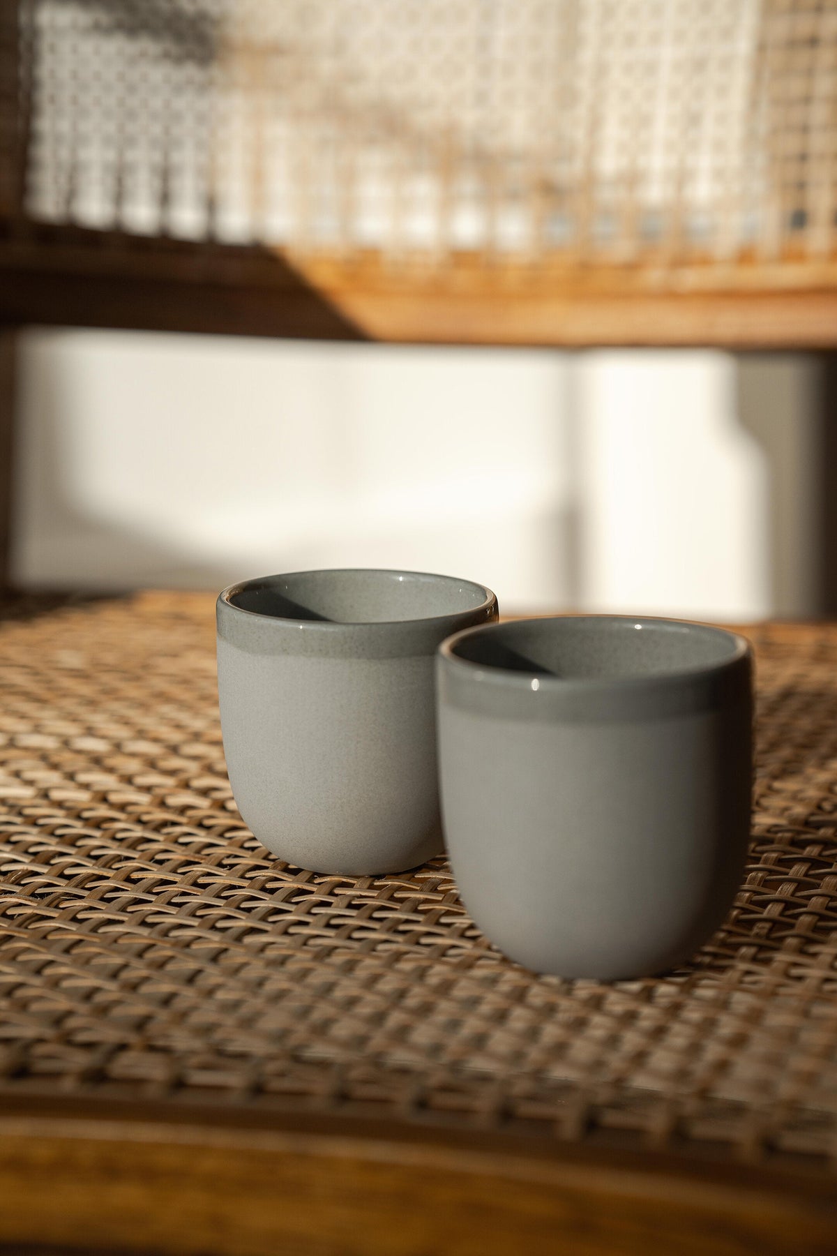 Handmade porcelain espresso cup with exposed clay exterior and glossy glazed interior on gray background