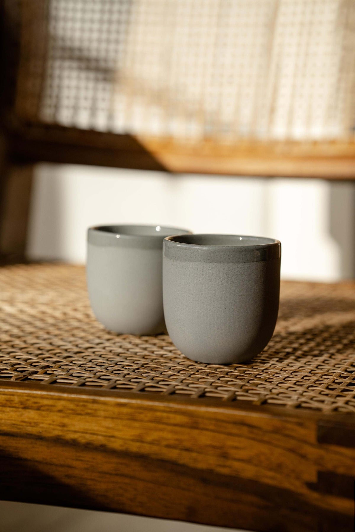 Handmade porcelain espresso cup with exposed clay exterior and glazed interior on gray background