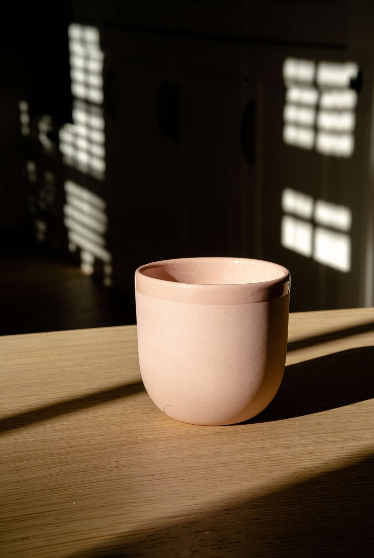 Handmade powder pink porcelain coffee cup with glossy interior and smooth exterior, dishwasher and microwave safe