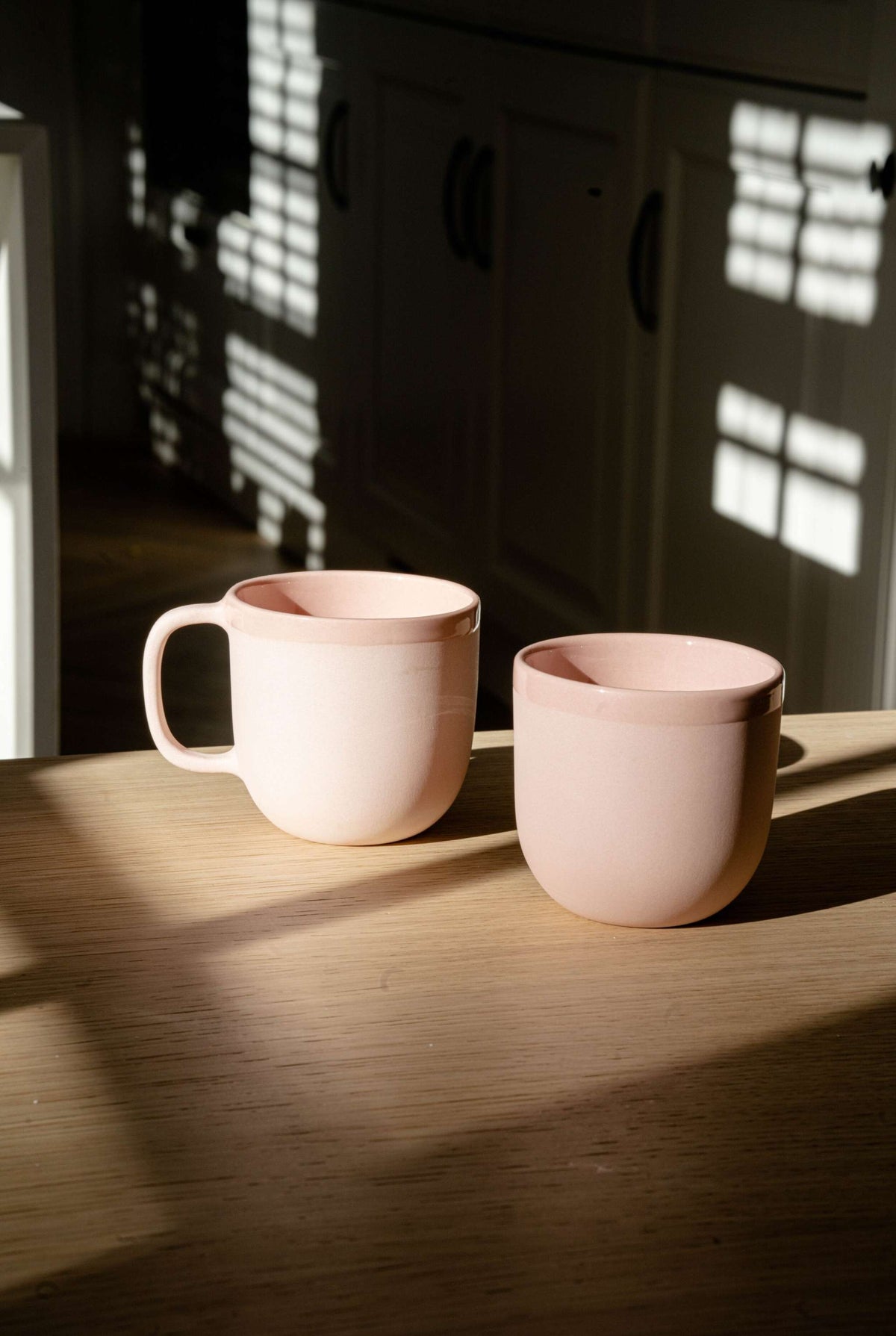 Handmade porcelain coffee cup in powder pink with shiny glazed interior and polished exterior