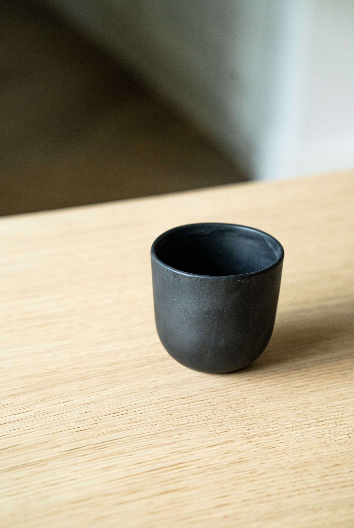 Black matte handmade stoneware cup with organic edges for coffee and tea, dishwasher and microwave safe