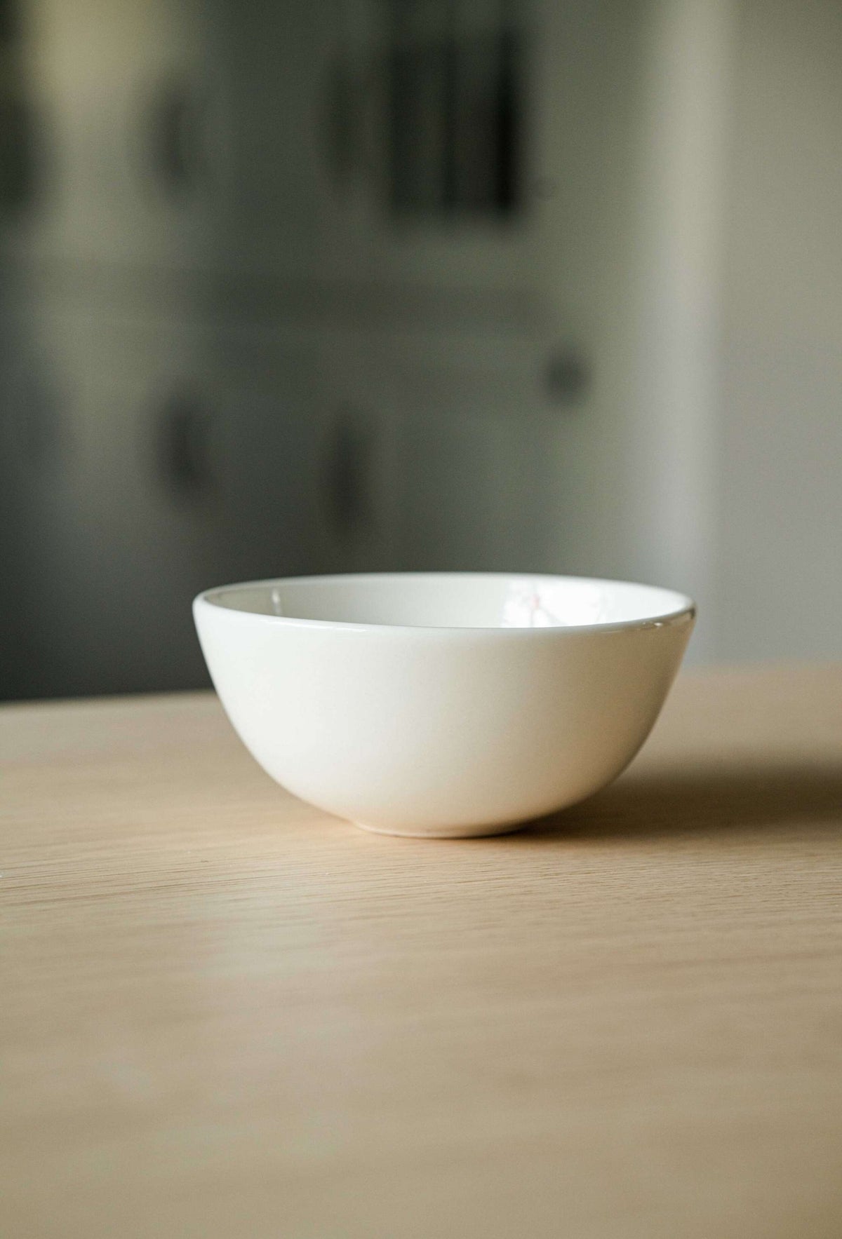 Handmade off-white porcelain bowl with shiny glaze and red heart detail