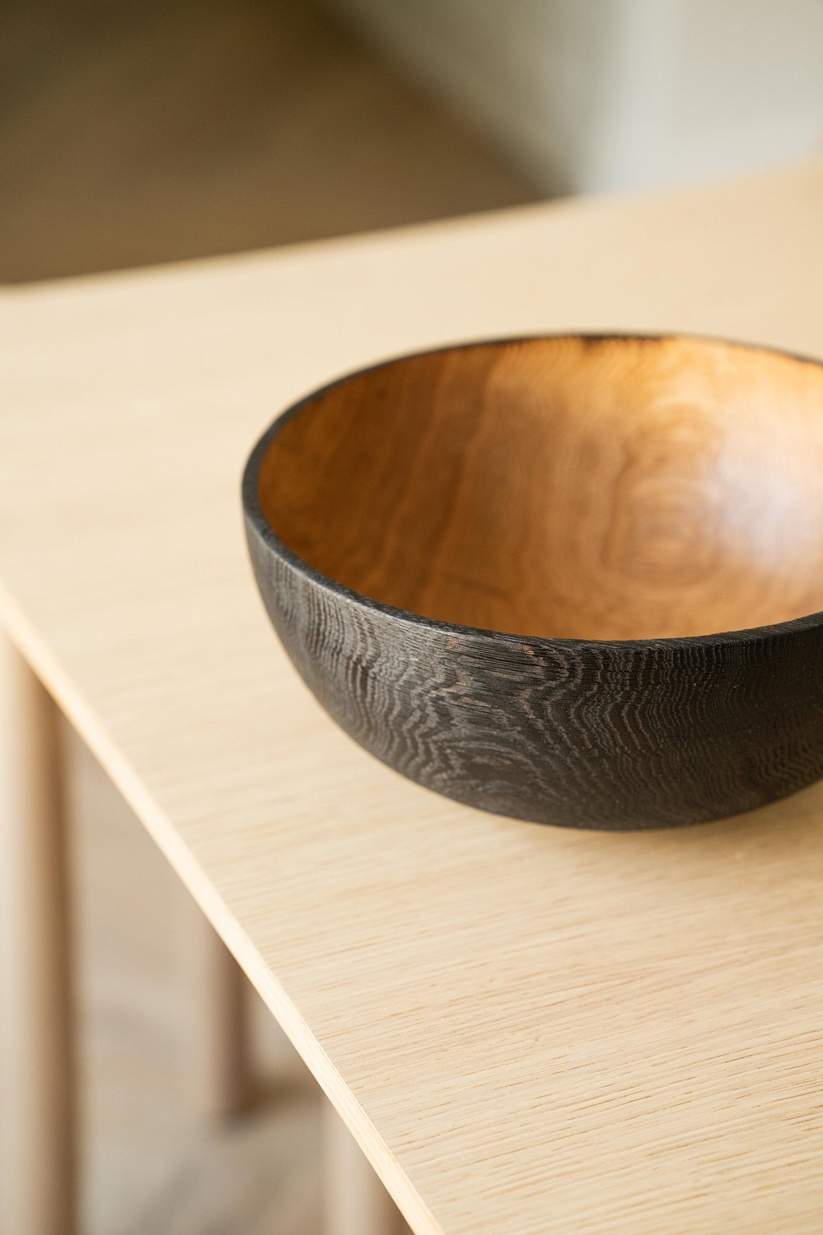 Hand carved large half charred wooden bowl with natural wood texture and blackened exterior
