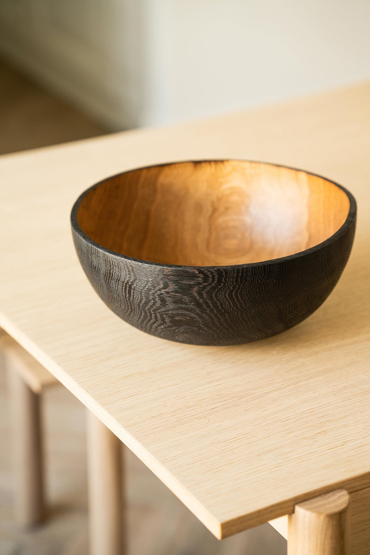 Hand carved large half charred wooden bowl with blackened exterior and natural wood texture