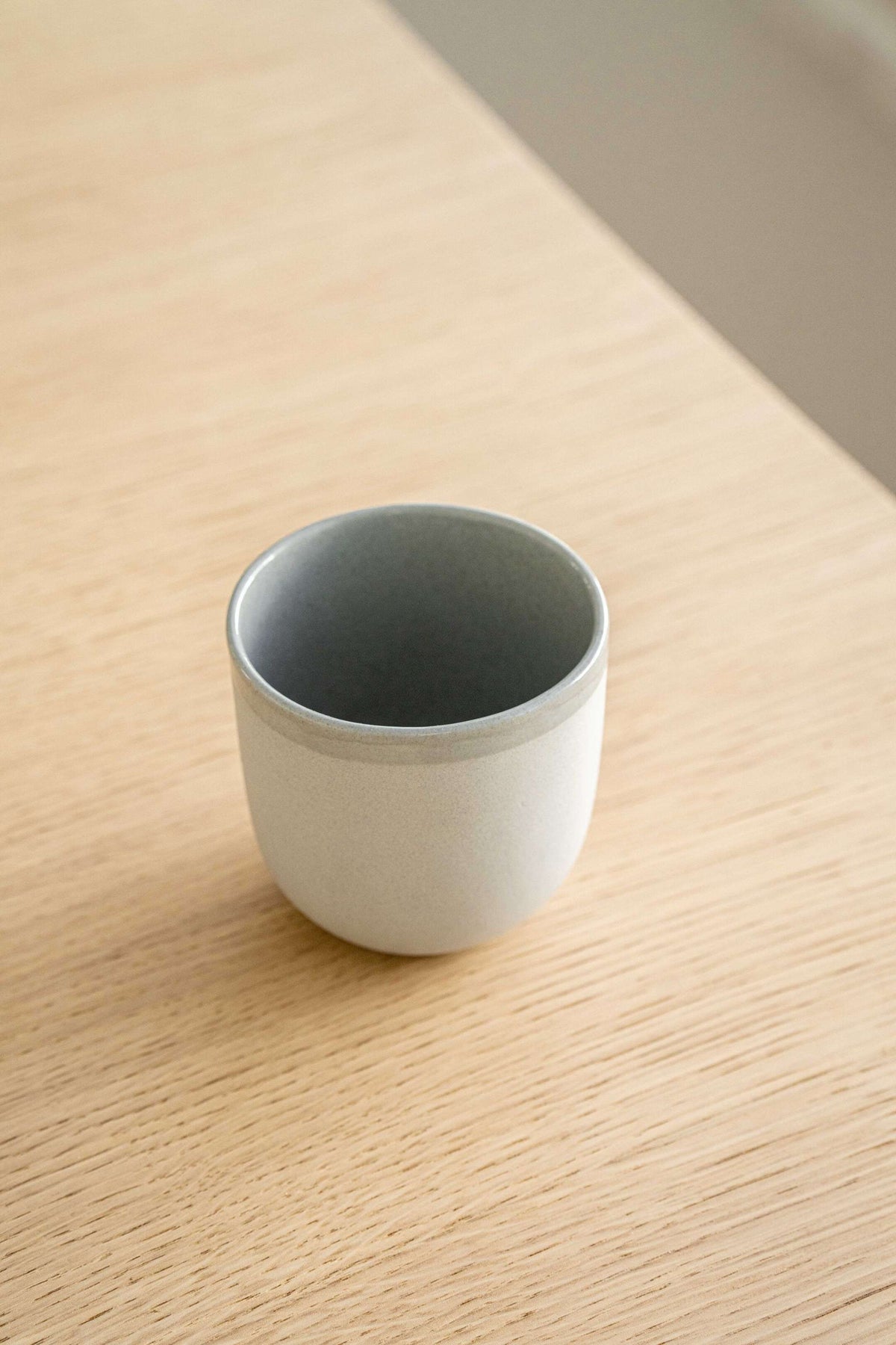 Handmade porcelain coffee cup in gray sky color with glossy glaze, polished finish, and unique texture